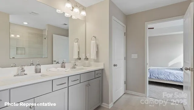 a en suite bathroom with a double vanity sink a mirror and a shower