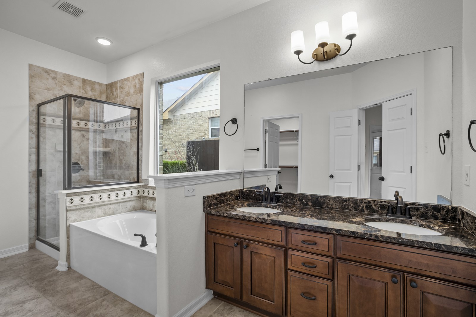 245 Razzmatazz Trail Buda, TX 78610 - Photo 19 of 37 Double vanity with dark wood cabinetry, dark stone countertop, and dual undermount sinks
