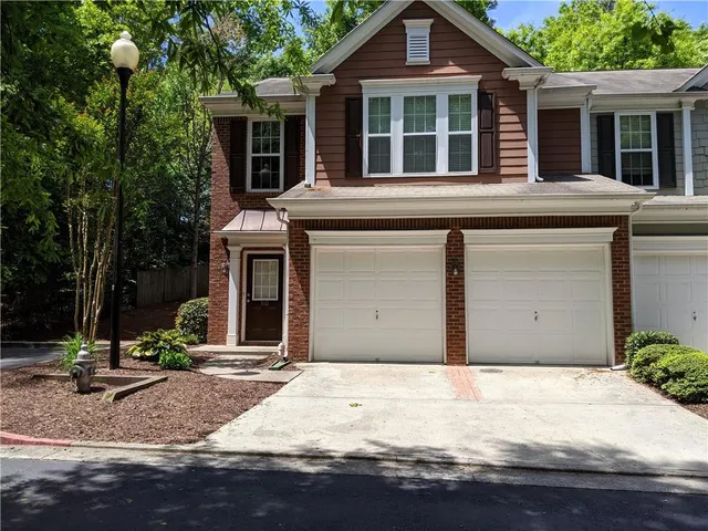 a view of a house with a yard and large tree