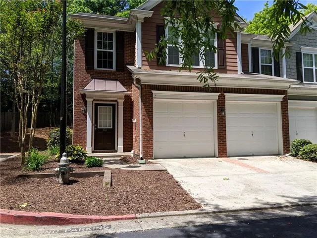 a view of a house with a yard and large tree