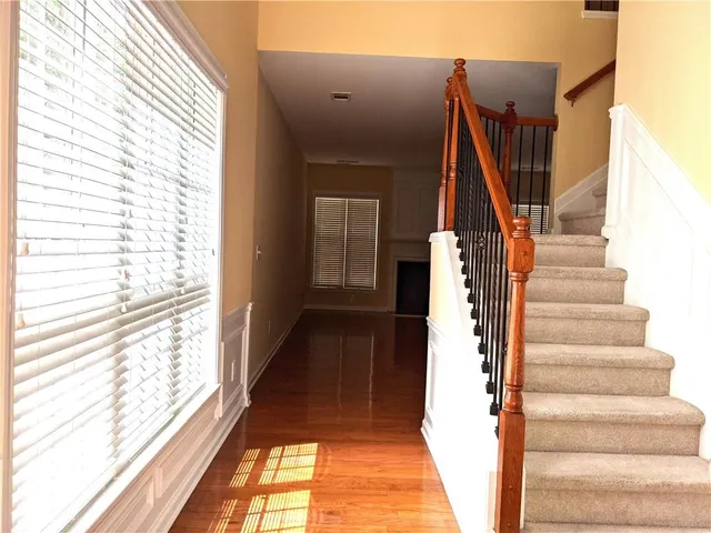 a view of a hallway with wooden floor and staircase