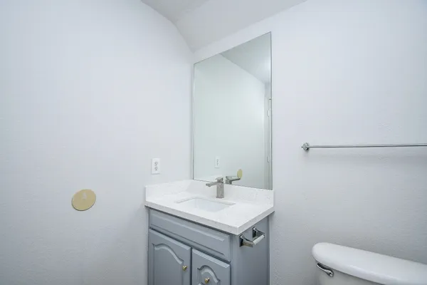 a bathroom with a sink a toilet and a mirror