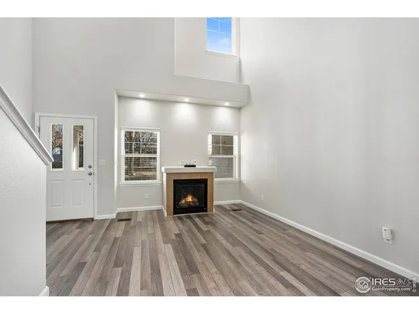 a view of empty room with wooden floor and fireplace