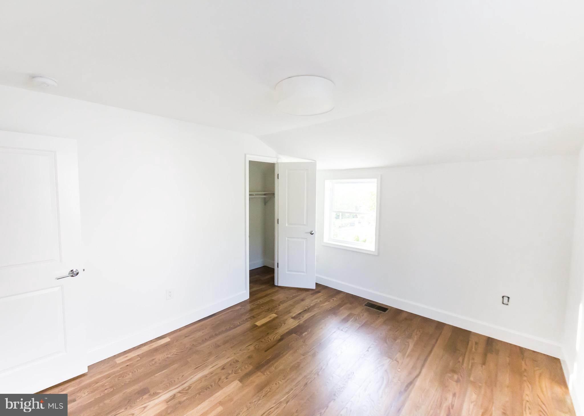 5151 Sheriff Road Northeast Washington, DC 20019 - Photo 11 of 20 an empty room with wooden floor and windows