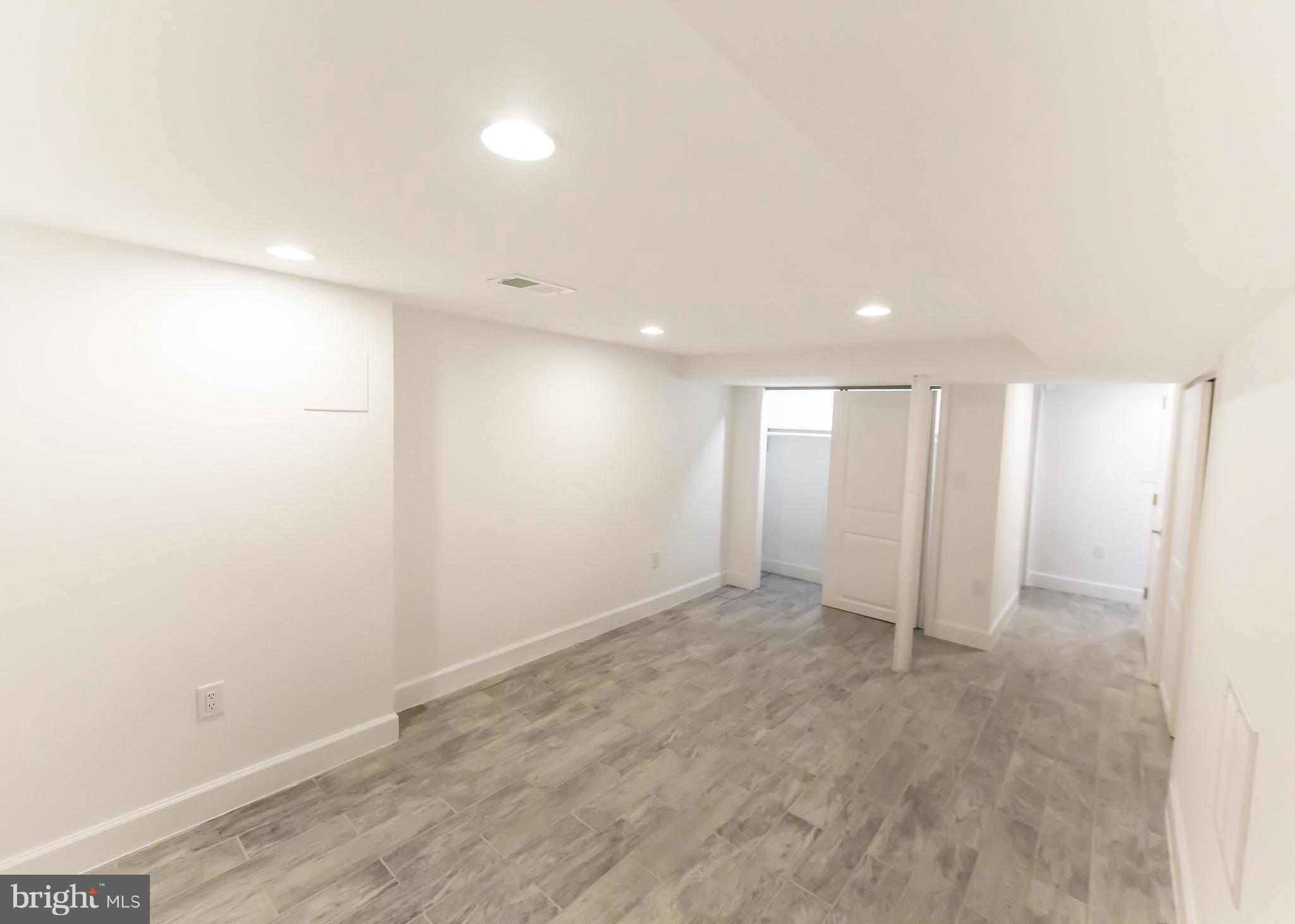 5151 Sheriff Road Northeast Washington, DC 20019 - Photo 15 of 20 an empty room with wooden floor and windows