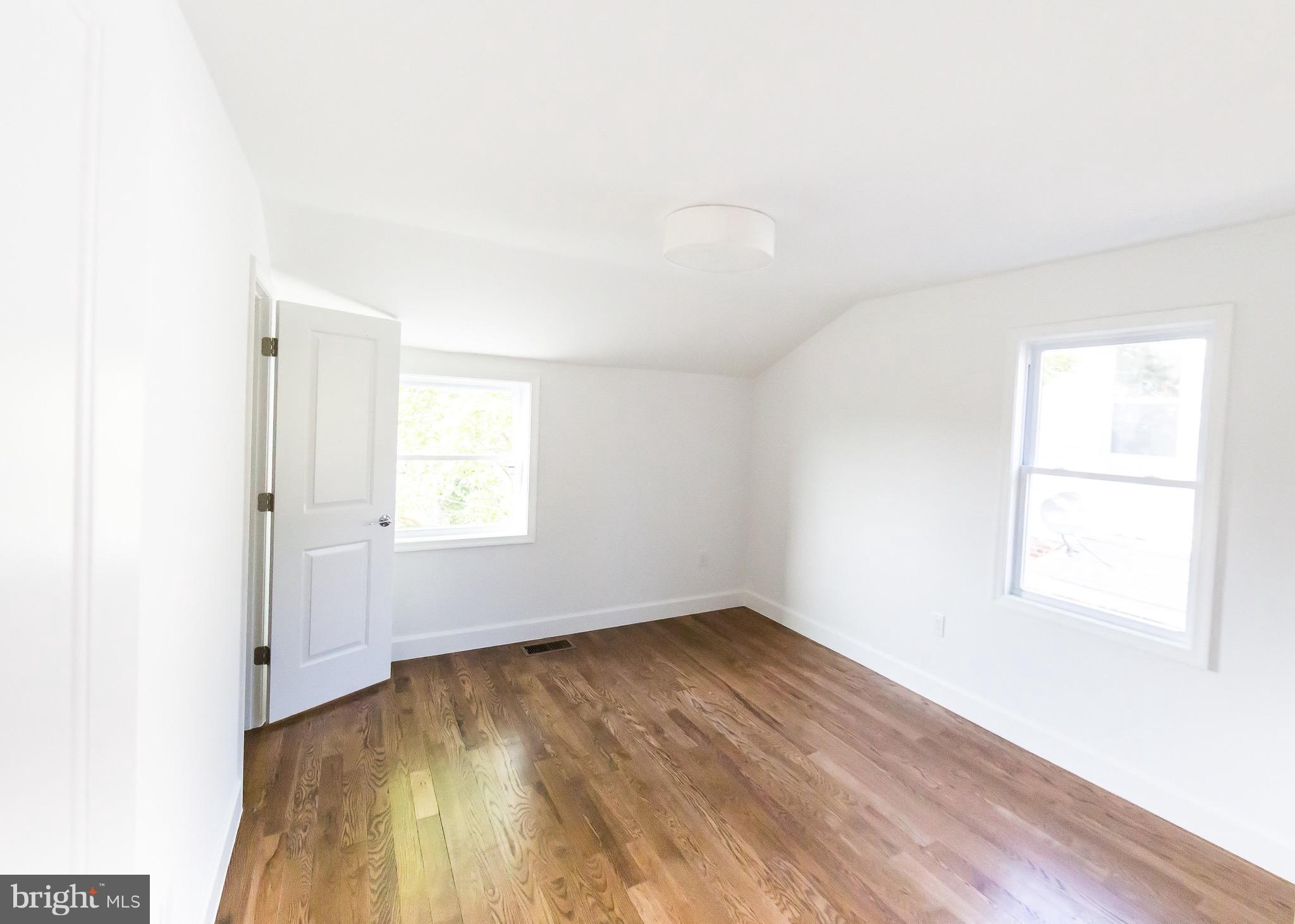 5151 Sheriff Road Northeast Washington, DC 20019 - Photo 8 of 20 an empty room with wooden floor and windows