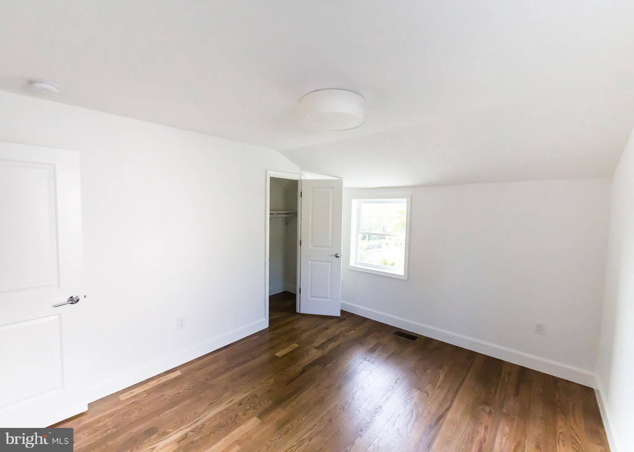 5151 Sheriff Road Northeast Washington, DC 20019 - Photo 9 of 20 an empty room with wooden floor and windows