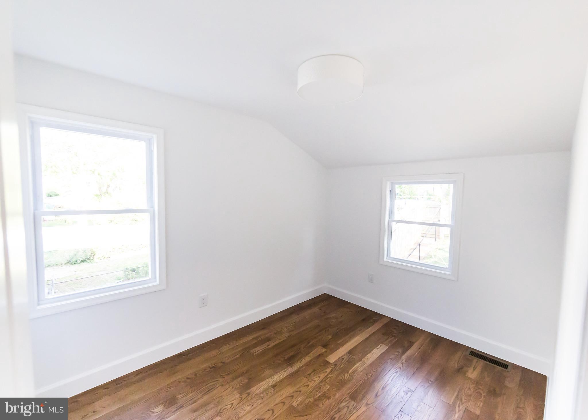 5151 Sheriff Road Northeast Washington, DC 20019 - Photo 10 of 20 an empty room with wooden floor and windows