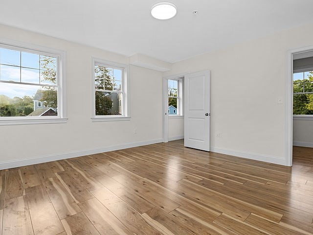 1 Pleasant Street, Unit 205 Cohasset, MA 02025 - Photo 4 of 24 an empty room with wooden floor and windows