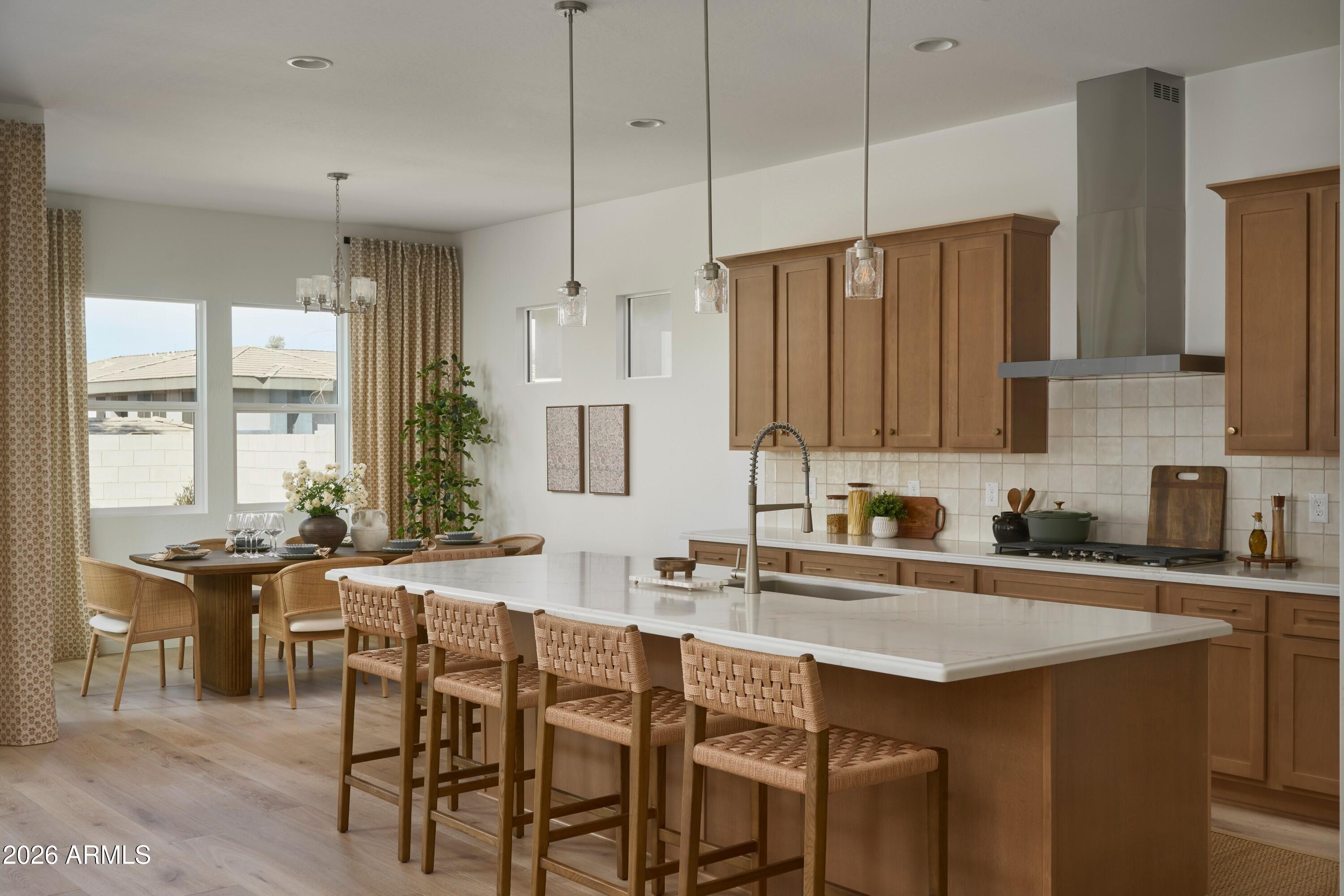 3705 East Constance Way Phoenix, AZ 85042 - Photo 3 of 10 a kitchen with stainless steel appliances granite countertop a table chairs sink and cabinets