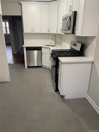 a kitchen with stainless steel appliances white cabinets and a stove