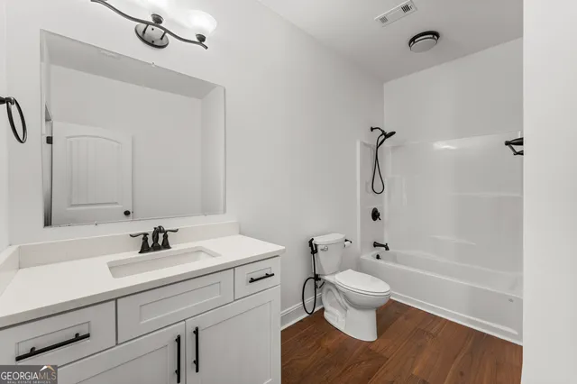 a bathroom with a sink a toilet and a large mirror