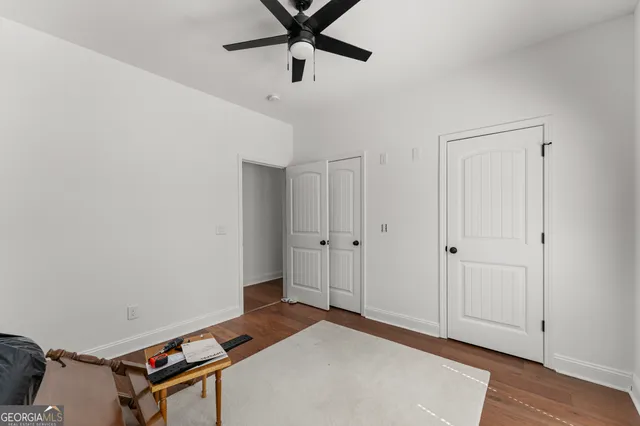 a room with chandelier fan and windows