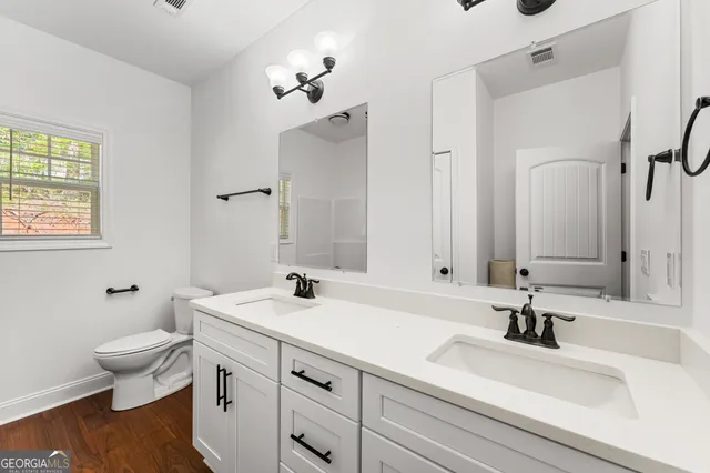 a bathroom with a sink a toilet and a mirror