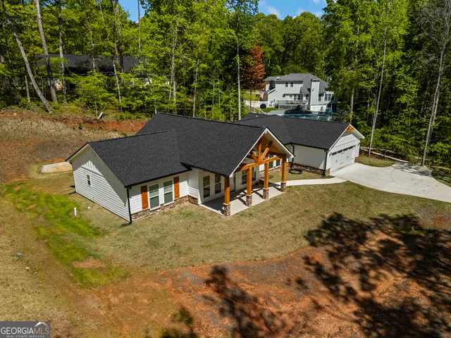 an aerial view of a house with swimming pool and green space