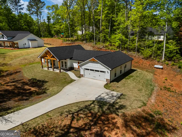 an aerial view of a house with a yard basket ball court and outdoor seating