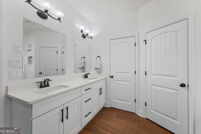 a bathroom with double vanity sinks and a mirror