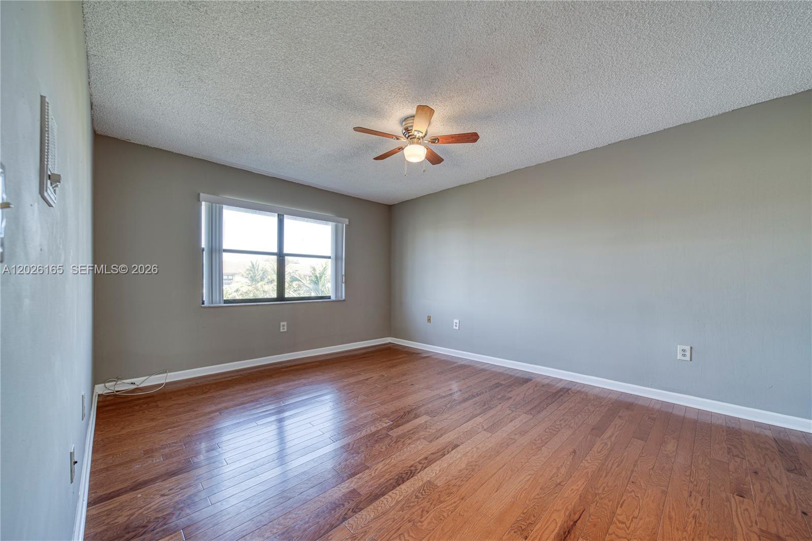 13337 Southwest 64th Lane Miami, FL 33183 - Photo 23 of 36 an empty room with wooden floor and a ceiling fan