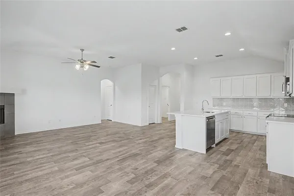 a view of a kitchen with a sink and dishwasher with wooden floor