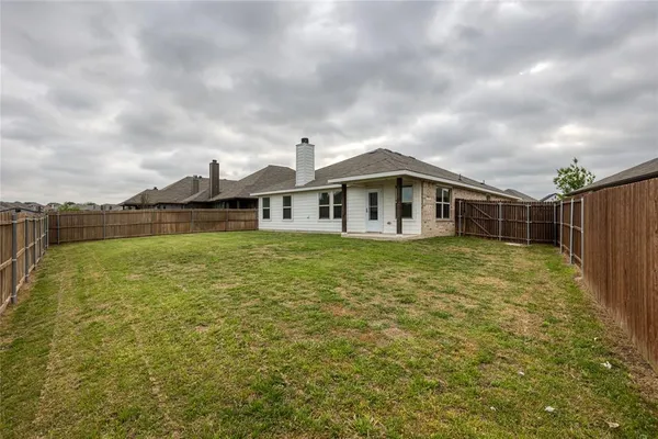 a view of a house with a yard and sitting area