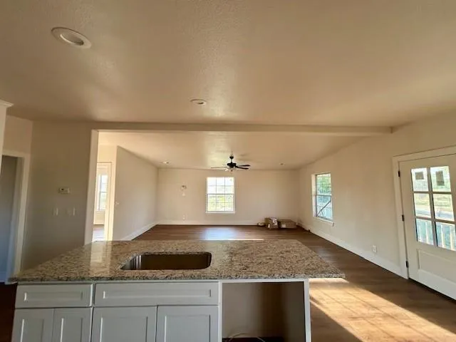 an empty room with wooden floor and window
