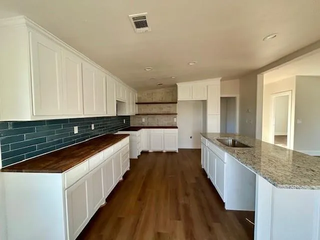 a kitchen with granite countertop white cabinets and white appliances