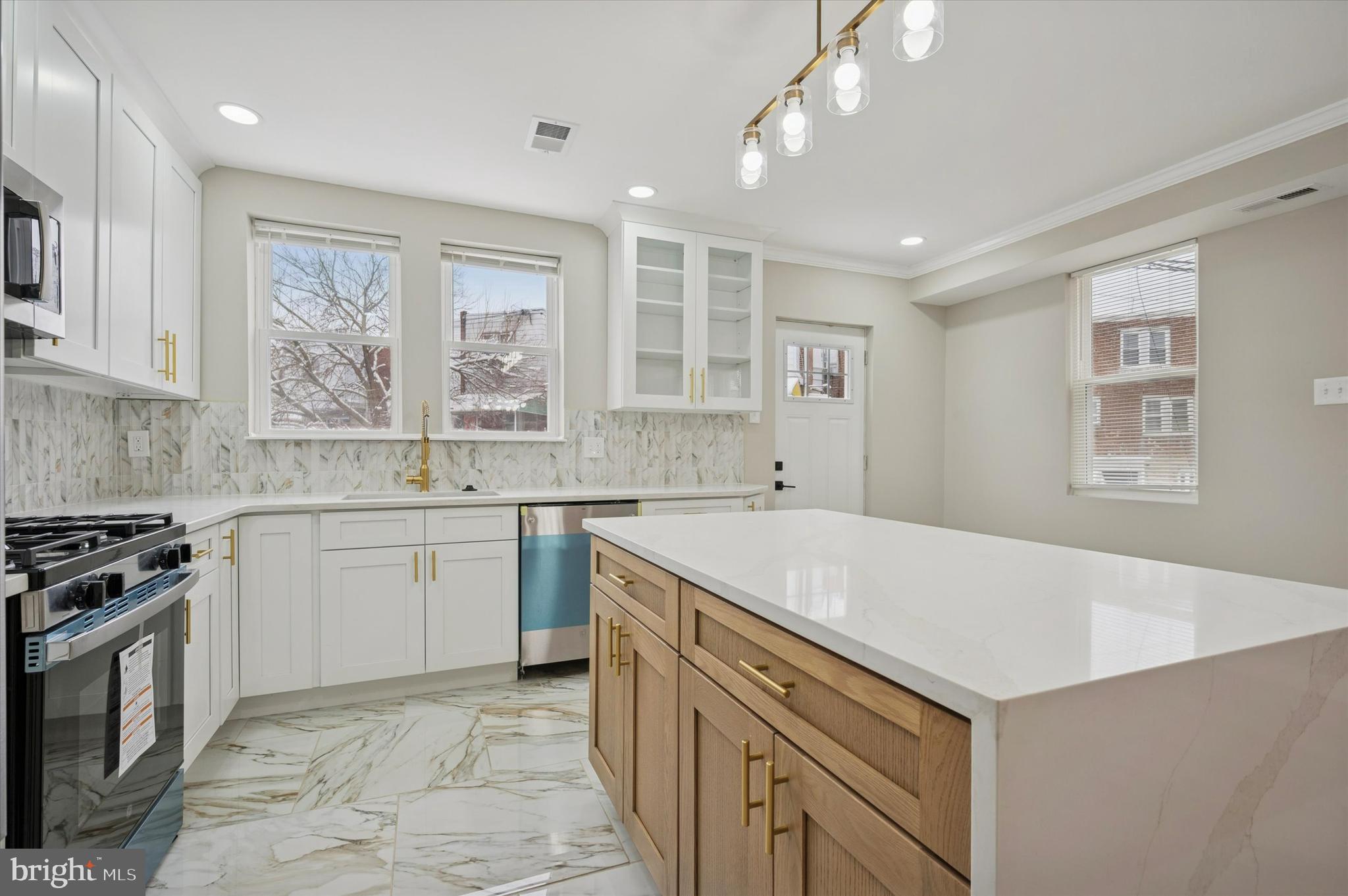 6866 North 19th Street Philadelphia, PA 19126 - Photo 11 of 28 a kitchen that has a sink a stove and chairs in it