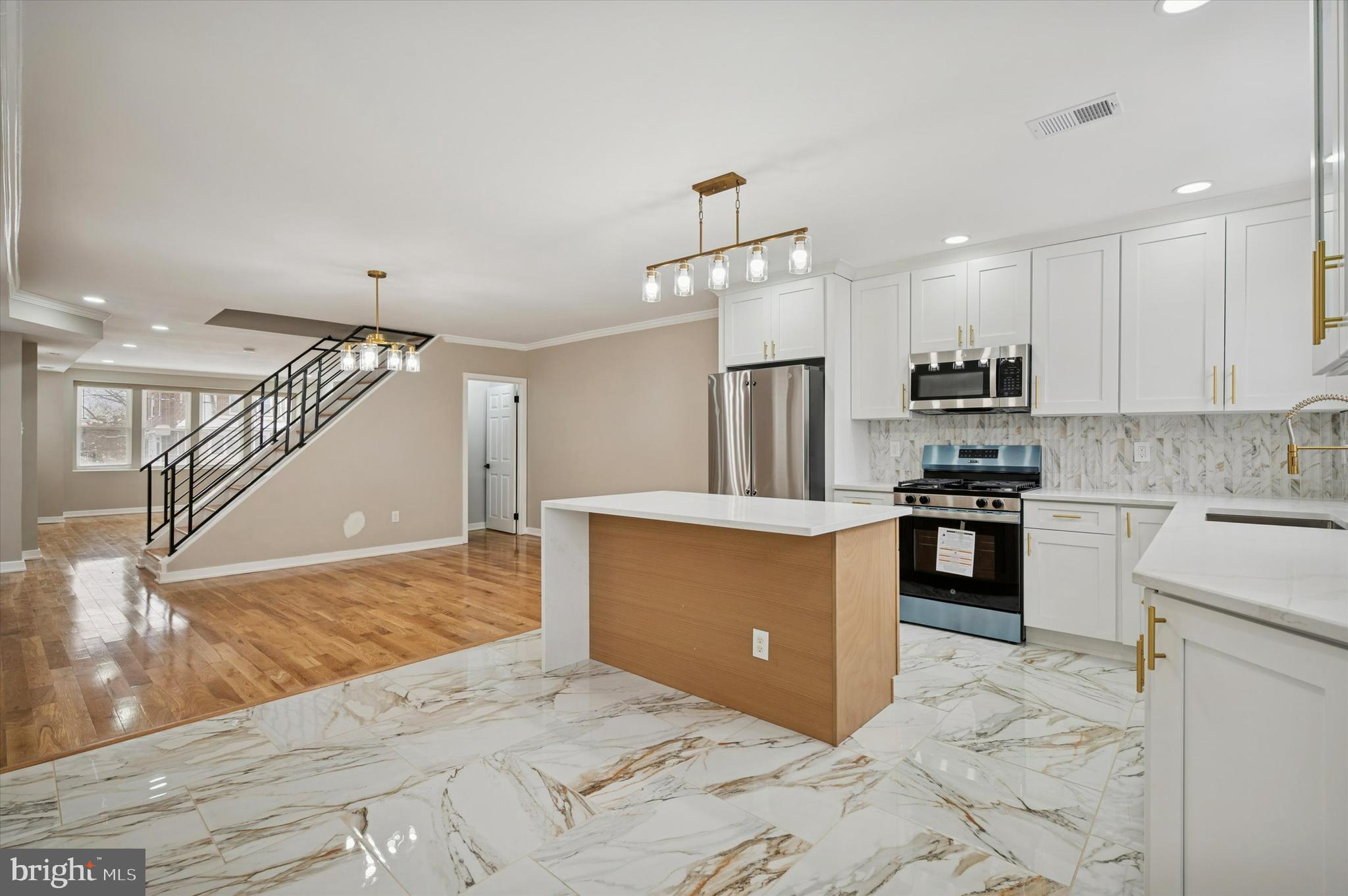 6866 North 19th Street Philadelphia, PA 19126 - Photo 12 of 28 a kitchen with kitchen island granite countertop a stove a sink and a refrigerator with cabinets