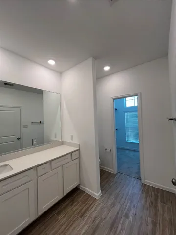 a view of bathroom with a sink mirror and window