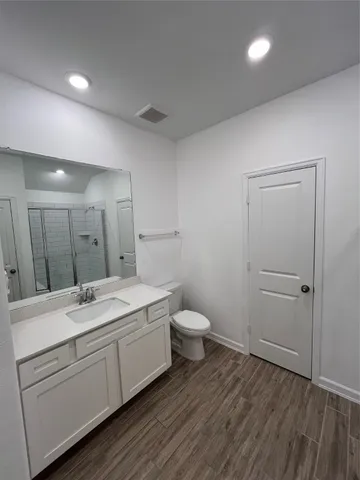 an empty room with wooden floor and mirror