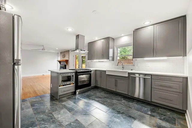 a kitchen with stainless steel appliances a sink cabinets and a wooden floor