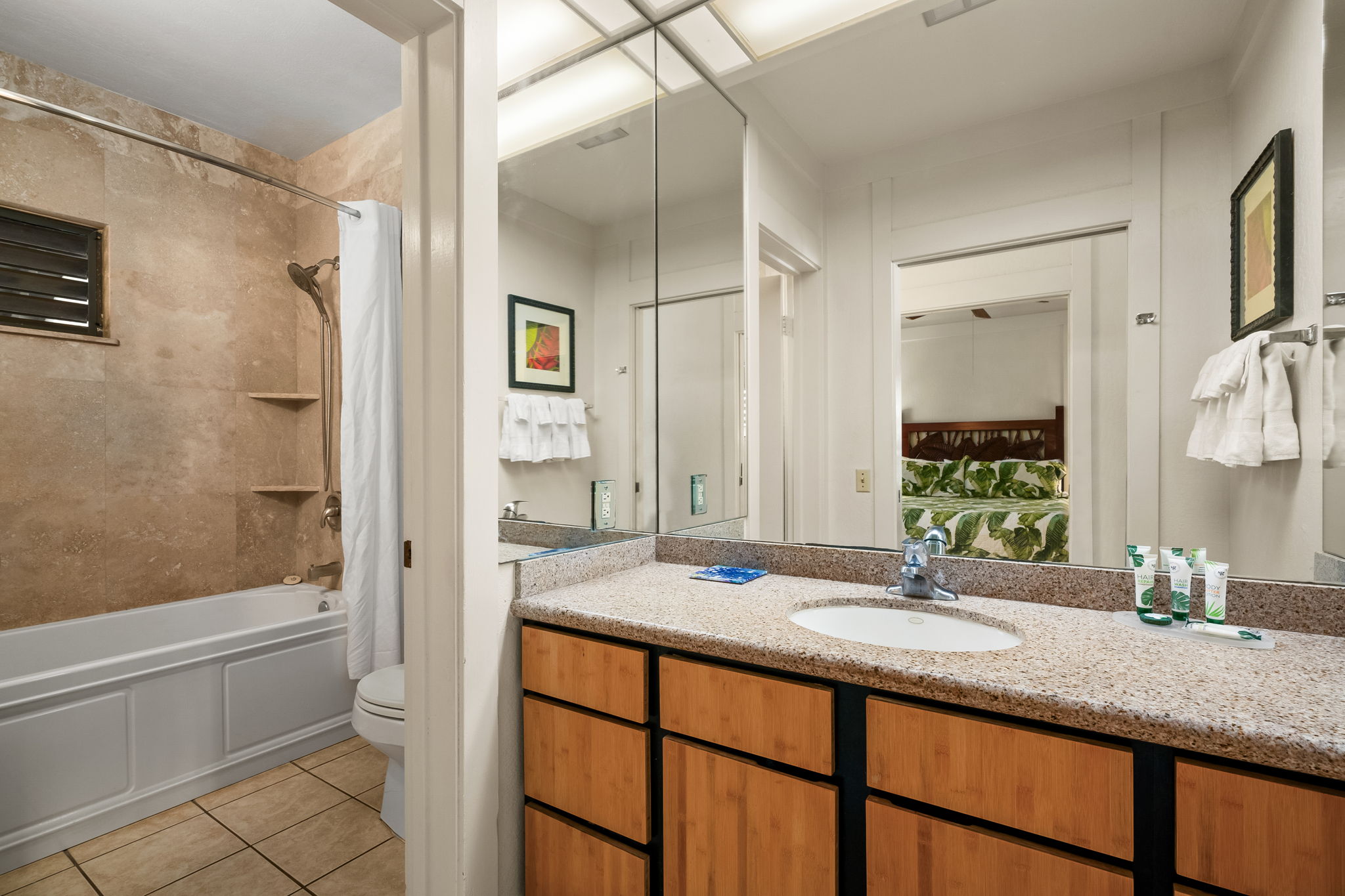 2253 Poipu Road, Unit 55 Koloa, HI 96756 - Photo 5 of 21 a bathroom with a granite countertop sink mirror toilet and bathtub
