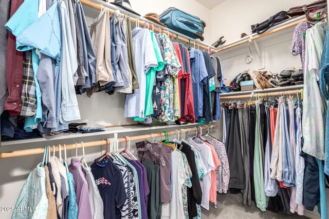 a view of walk in closet with clothes and shoes