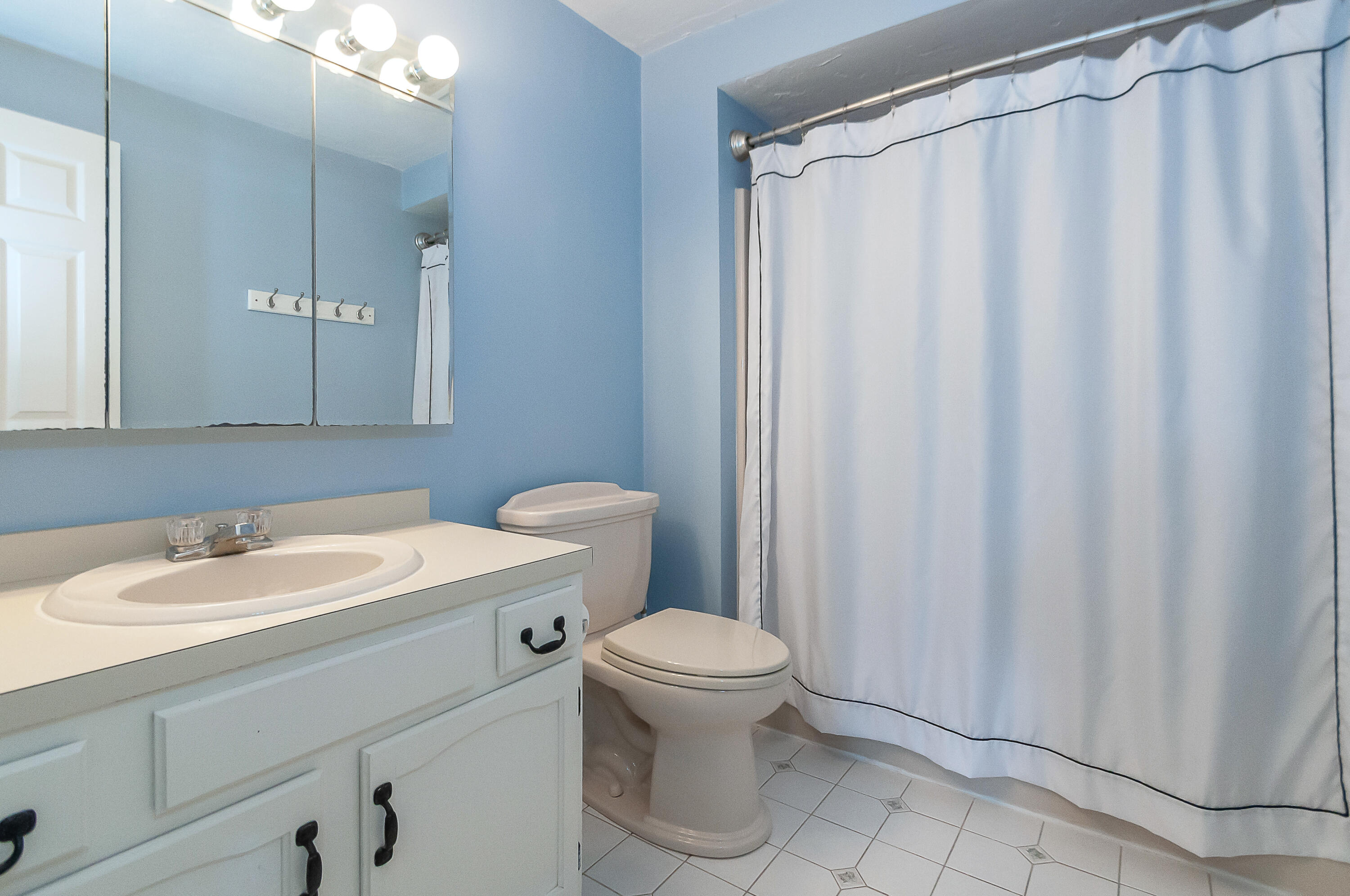 36 Atkins Road, Unit E6 East Sandwich, MA 02537 - Photo 16 of 30 a bathroom with a sink a toilet and shower curtain