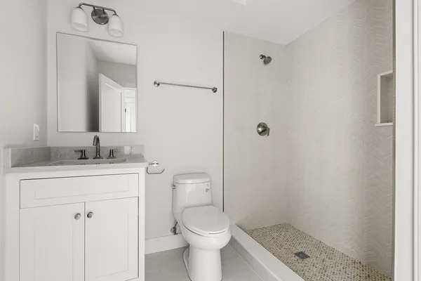 a bathroom with a sink a toilet and shower