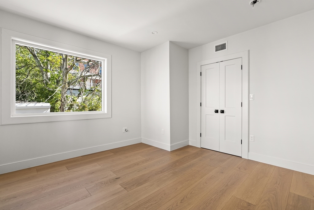 9 Armory Street Boston, MA 02129 - Photo 18 of 37 a view of an empty room with wooden floor and a window