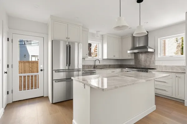 a kitchen with stainless steel appliances granite countertop a refrigerator a stove a sink dishwasher and a refrigerator