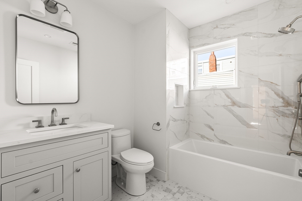 9 Armory Street Boston, MA 02129 - Photo 21 of 37 a bathroom with a toilet a sink a mirror a bathtub and vanity