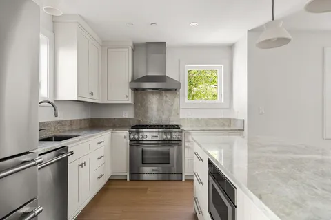 a kitchen with stainless steel appliances granite countertop a stove a sink and a microwave