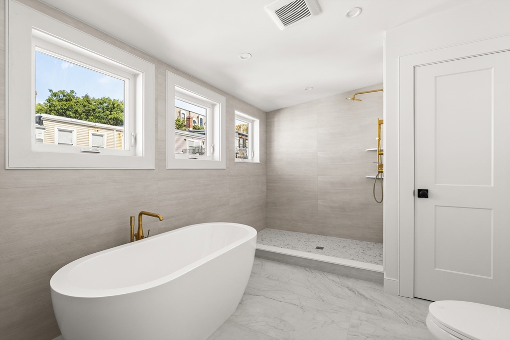 9 Armory Street Boston, MA 02129 - Photo 33 of 37 a white bath tub sitting next to a toilet