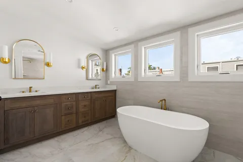 a white bath tub sitting next to a bathroom sink