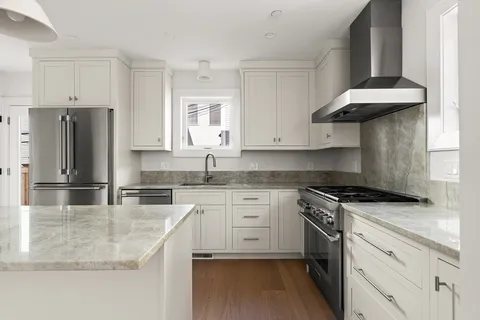 a kitchen with stainless steel appliances granite countertop a sink stove and refrigerator