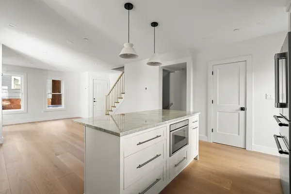 a kitchen with a stove a refrigerator a sink and a chandelier