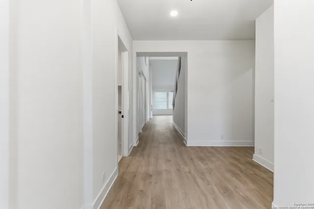 a view of a hallway with wooden floor