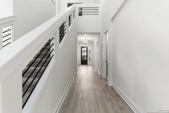 a view of a hallway with wooden floor and staircase