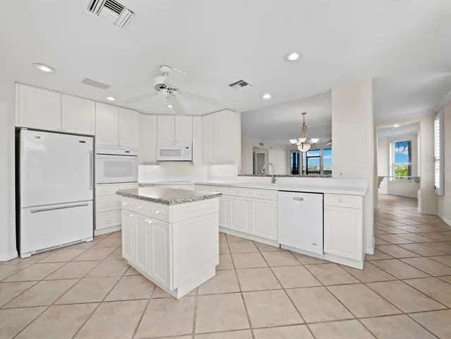 a kitchen with white cabinets appliances and center island