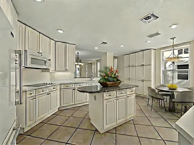 a kitchen with stainless steel appliances kitchen island granite countertop a sink and cabinets