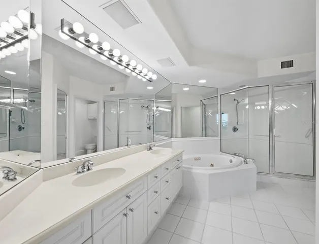a large bathroom with a double vanity sink a mirror and a bathtub