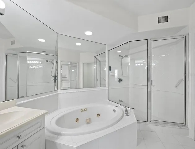 a bathroom with a tub a sink shower and mirror