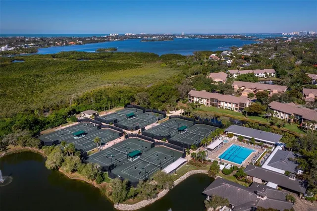 an aerial view of a city with lots of residential buildings ocean and mountain view in back